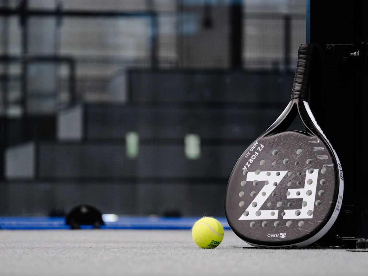 Raquette de padel et balle au bord du terrain