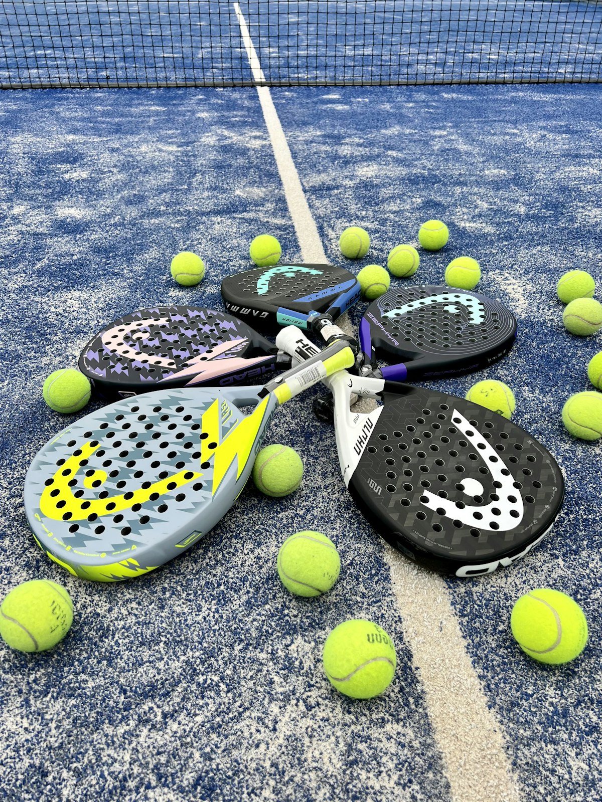 Raquettes de padel et balles au bord du filet